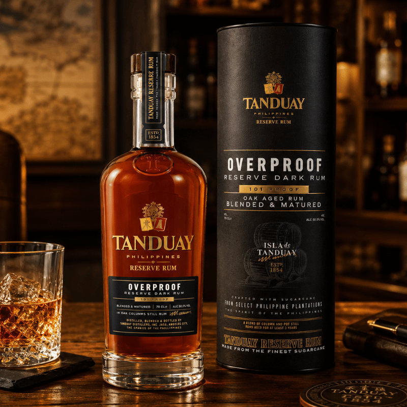 Tanduay Overproof Reserve Dark Rum bottle and packaging on a wooden surface with a glass of rum.