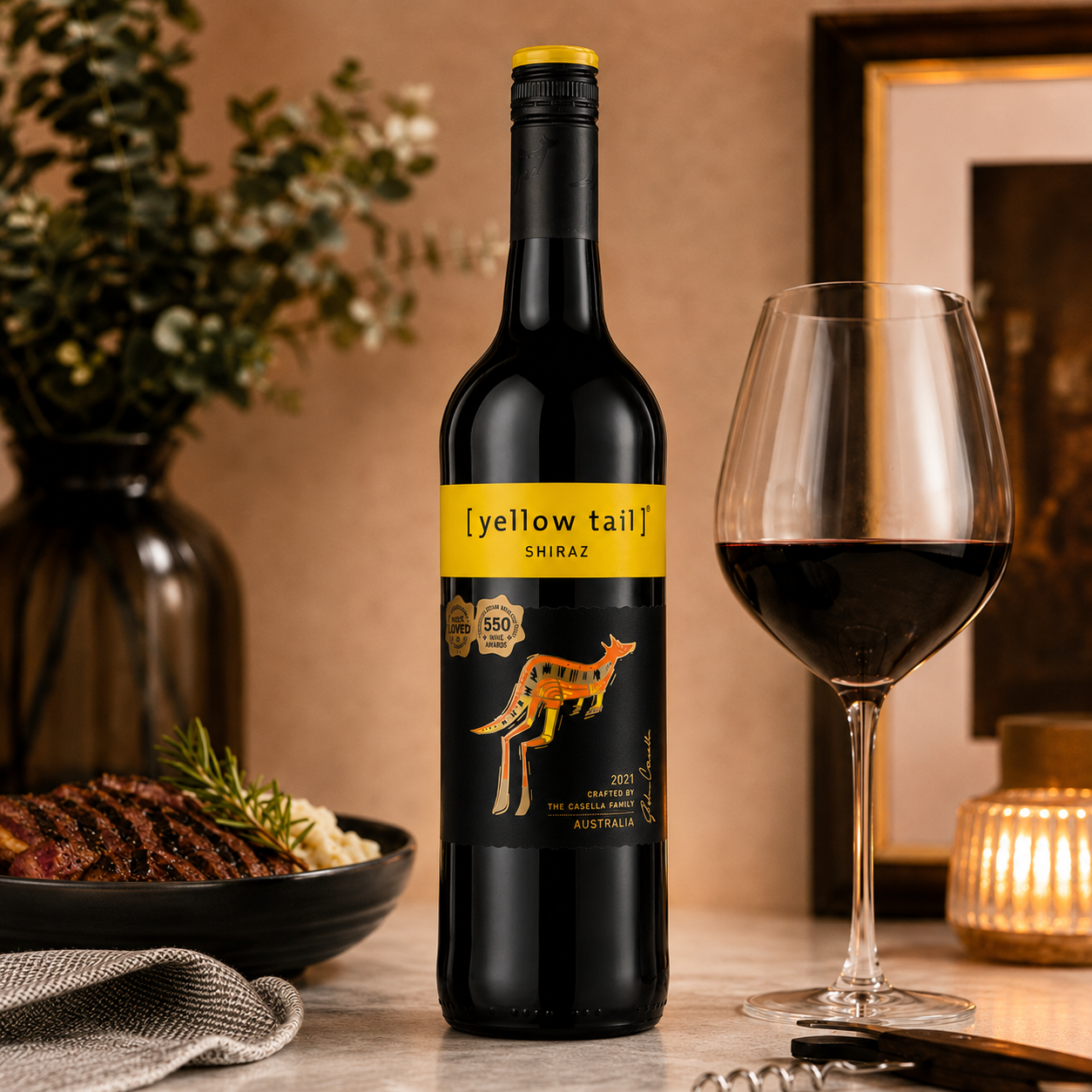 Yellow Tail Shiraz 750ml served in a red wine glass beside grilled steak and rosemary